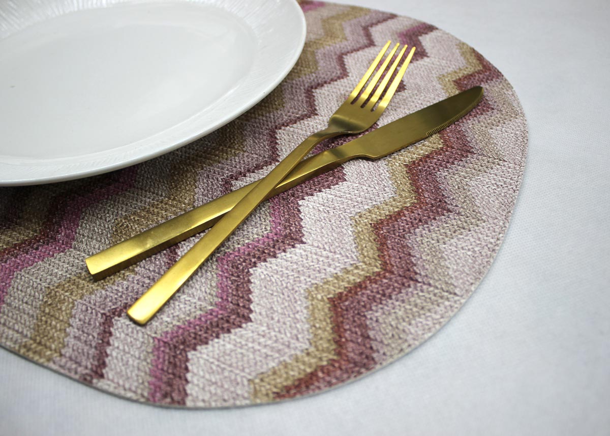 abgerundetes Platzset in rosa pink gemustert mit Teller und Besteck dekoriert