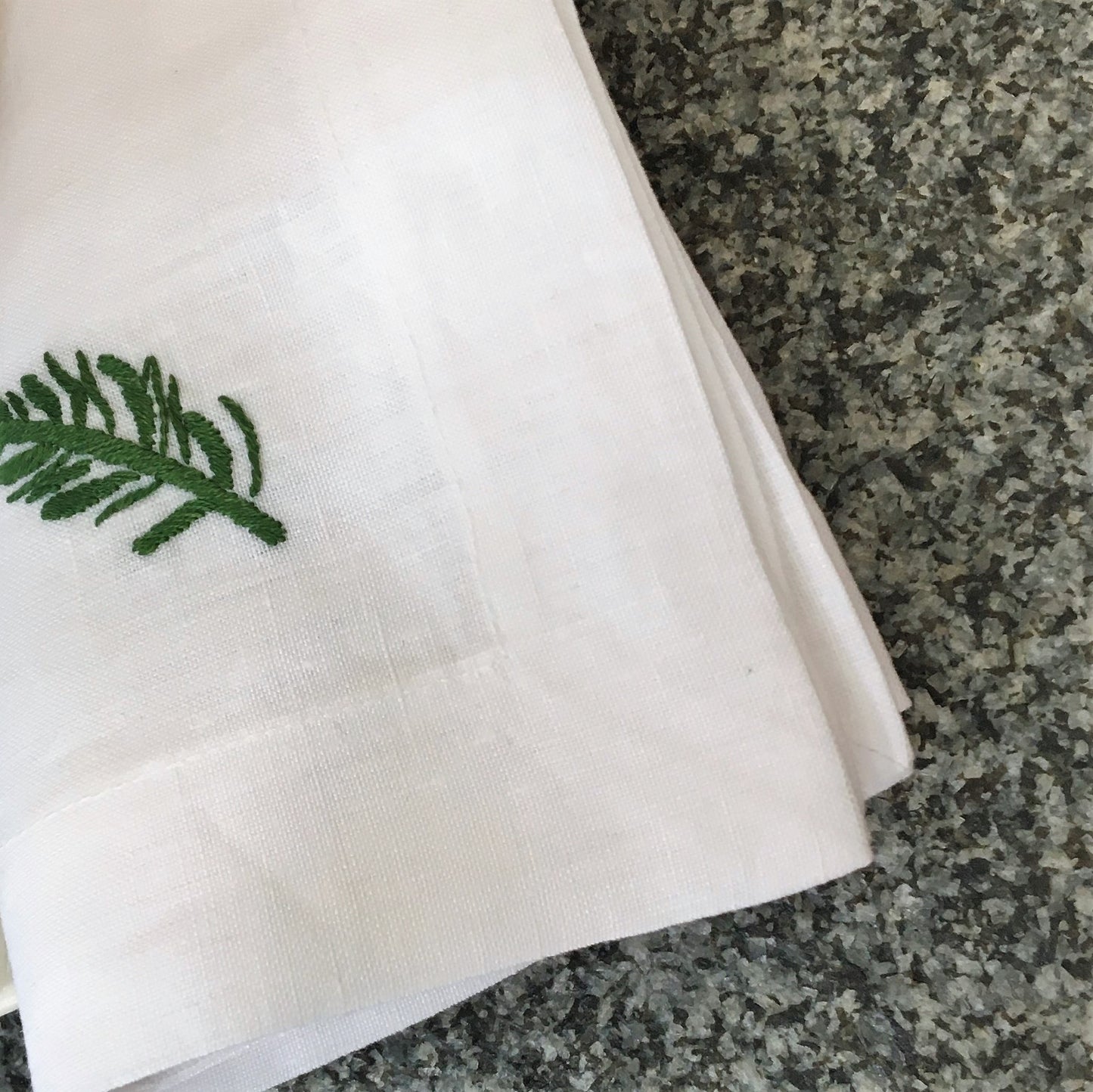 weiße Stoffserviette mit Zweig handbestickt