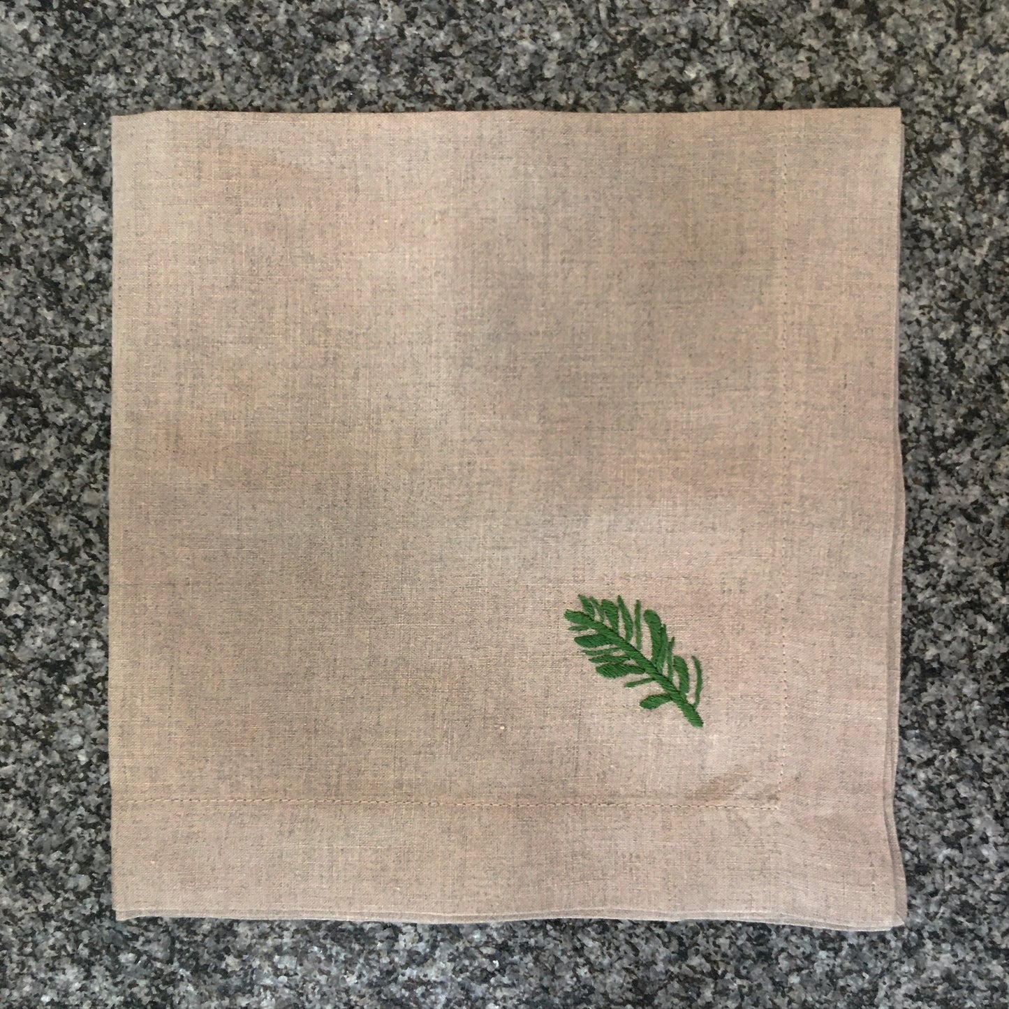 natur farbene, beige Serviette mit grünem Zweig bestickt handbestickt