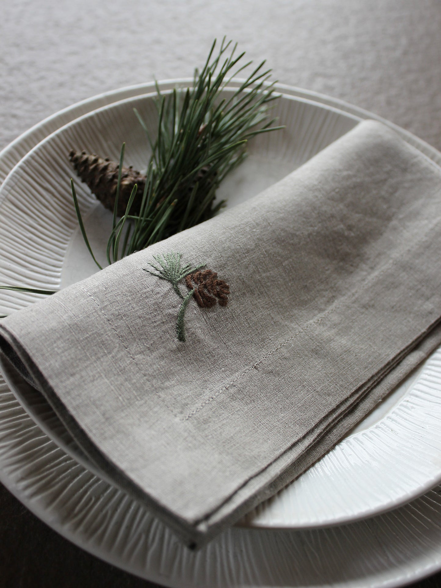 Leinenserviette handbestickt mit Zapfen als Weihnachtsdeko