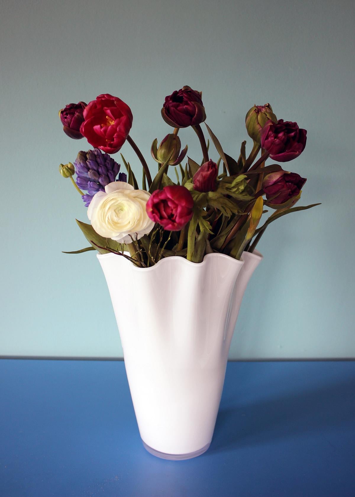 weiße Glasvase mit buntem Blumenstrauß
