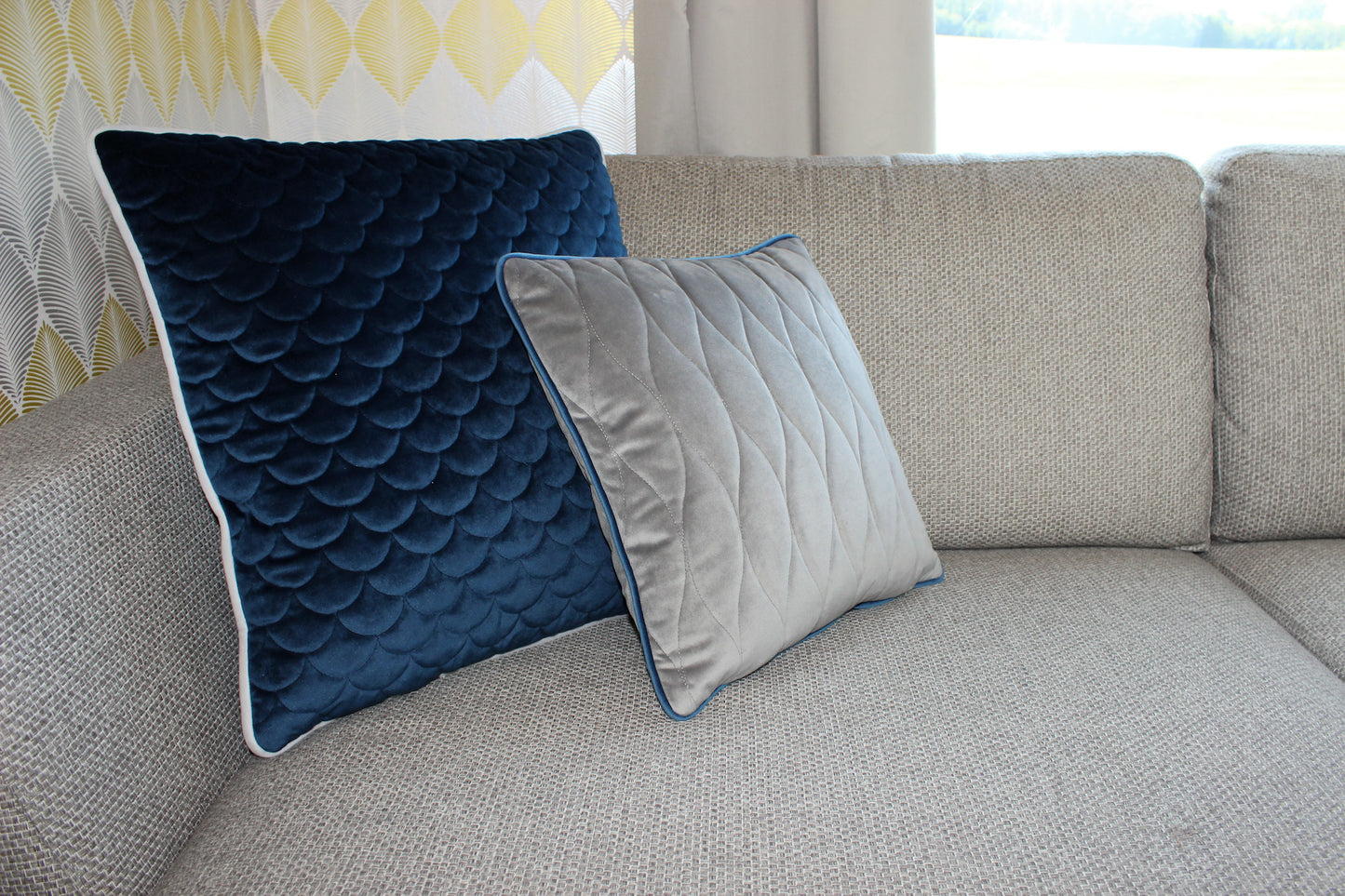 dunkelblaues und graues Kissen auf gemütlichem Sofa
