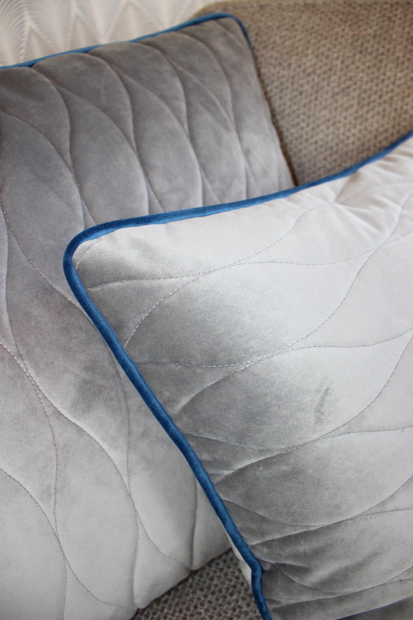 quadratisches Kissen in grau mit blau auf Sofa