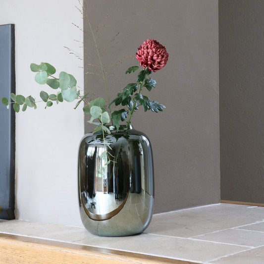 Breite Glasvase mit Spiegeloptik Dekoriert mit Blumen auf Fenstersims