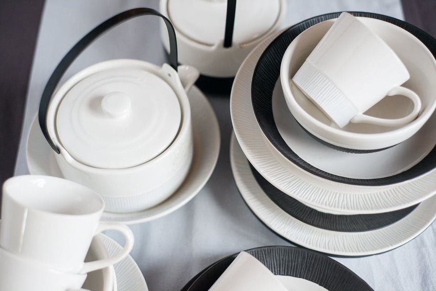 Tassen, Teller & Kaffeekanne in weiß und schwarz auf Esstisch dekoriert