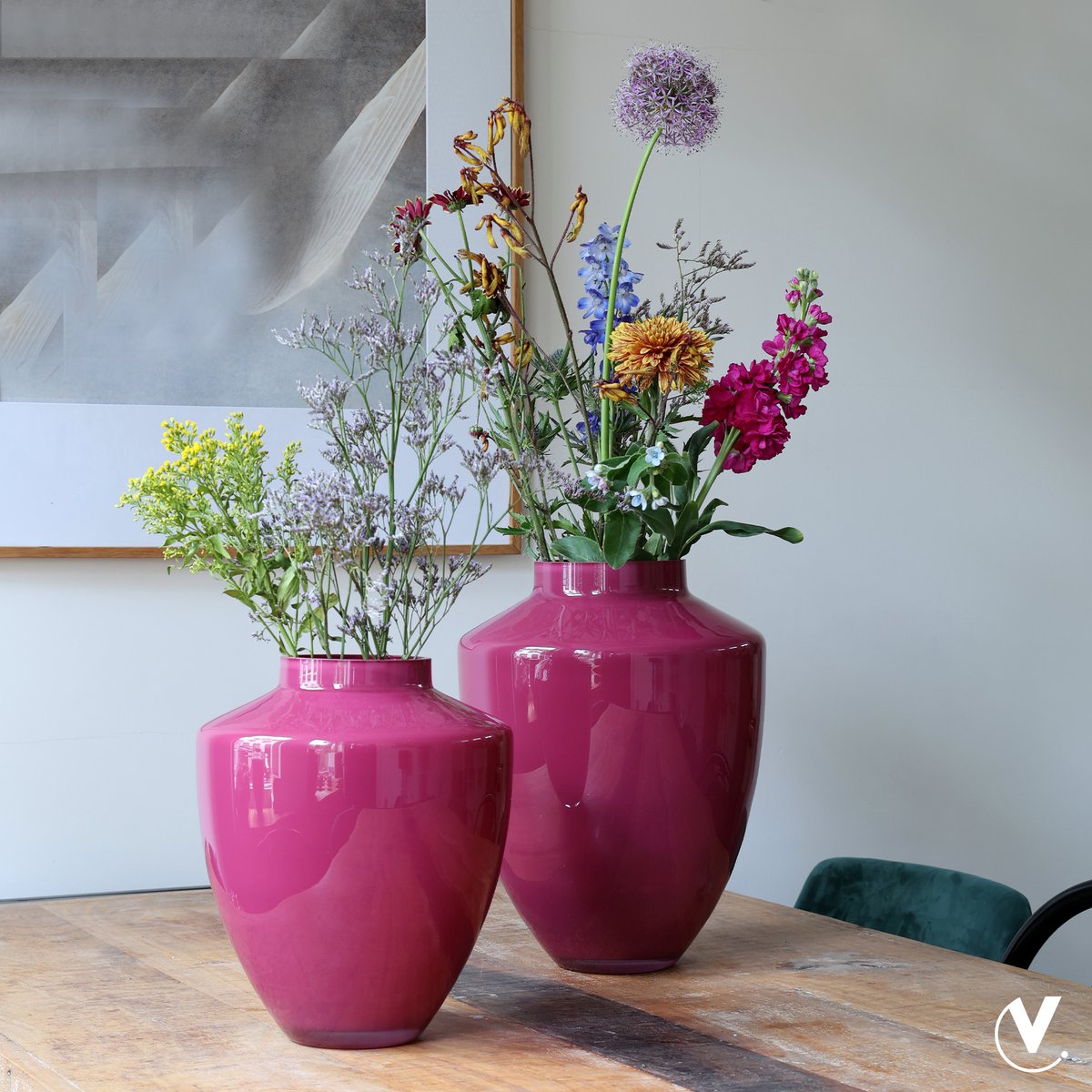 Kleine und große Vase in klassischer Form In Lila Mit Blumen dekoriert auf dem Esstisch