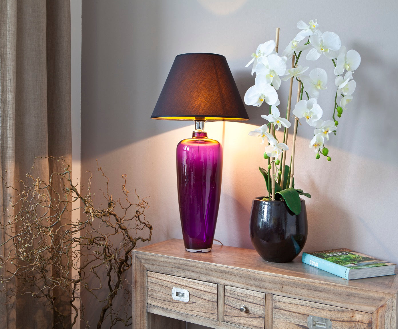 schmale Glaslampe aus lila Glas auf Konsole dekoriert