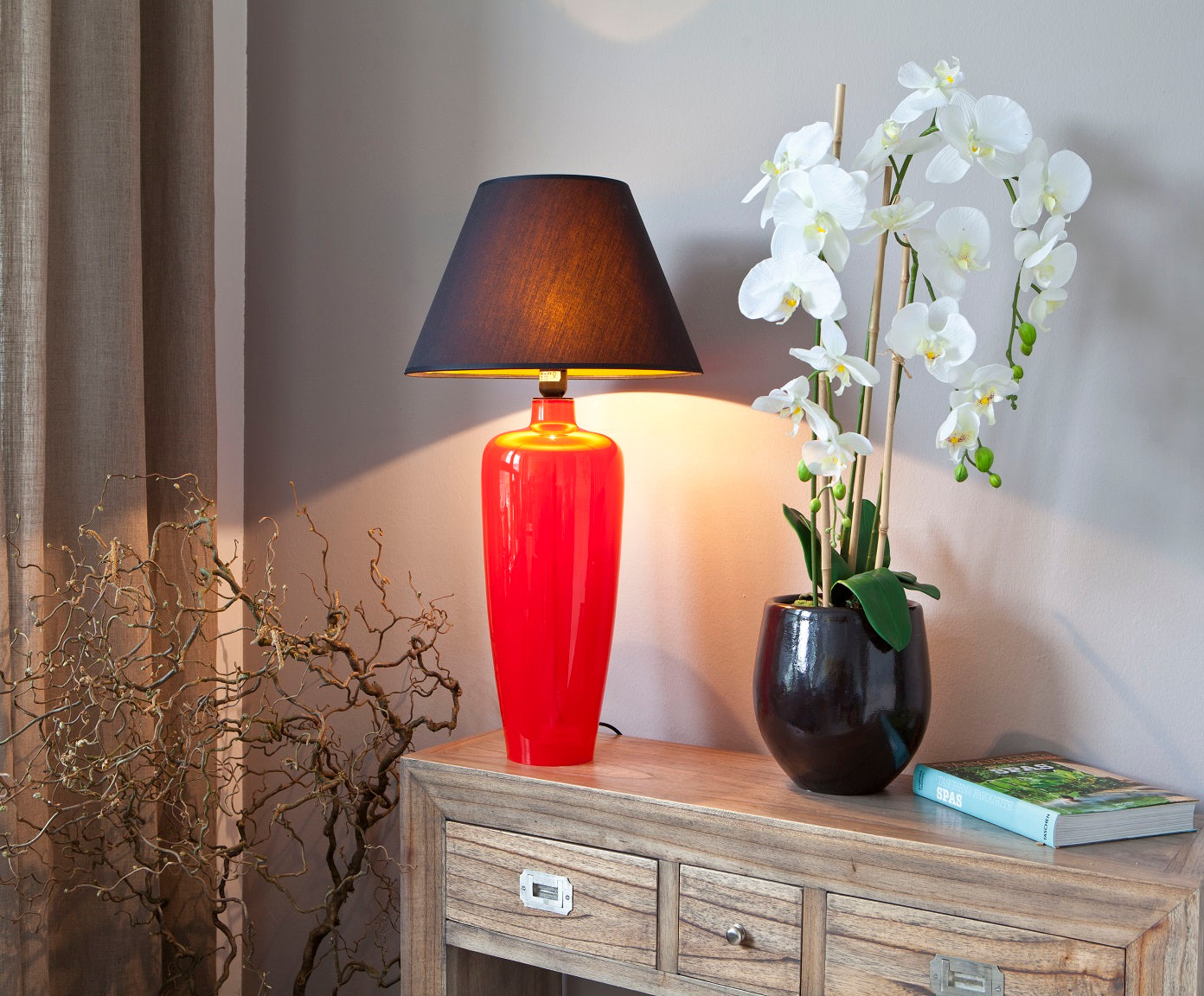 Lampe schmal in rot auf Konsole mit Orchideen