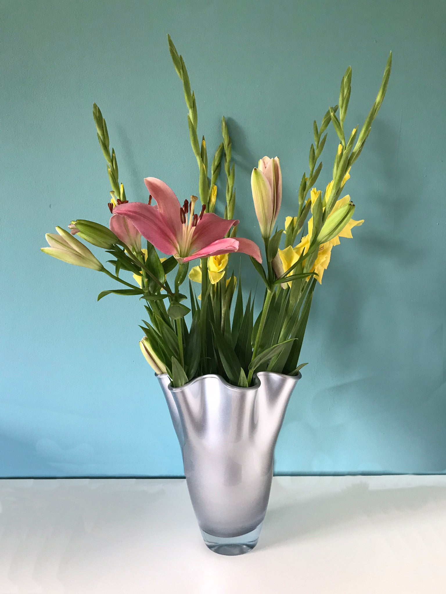 Vase aus silbernem Glas glänzend mit sommerlichem Strauß dekoriert
