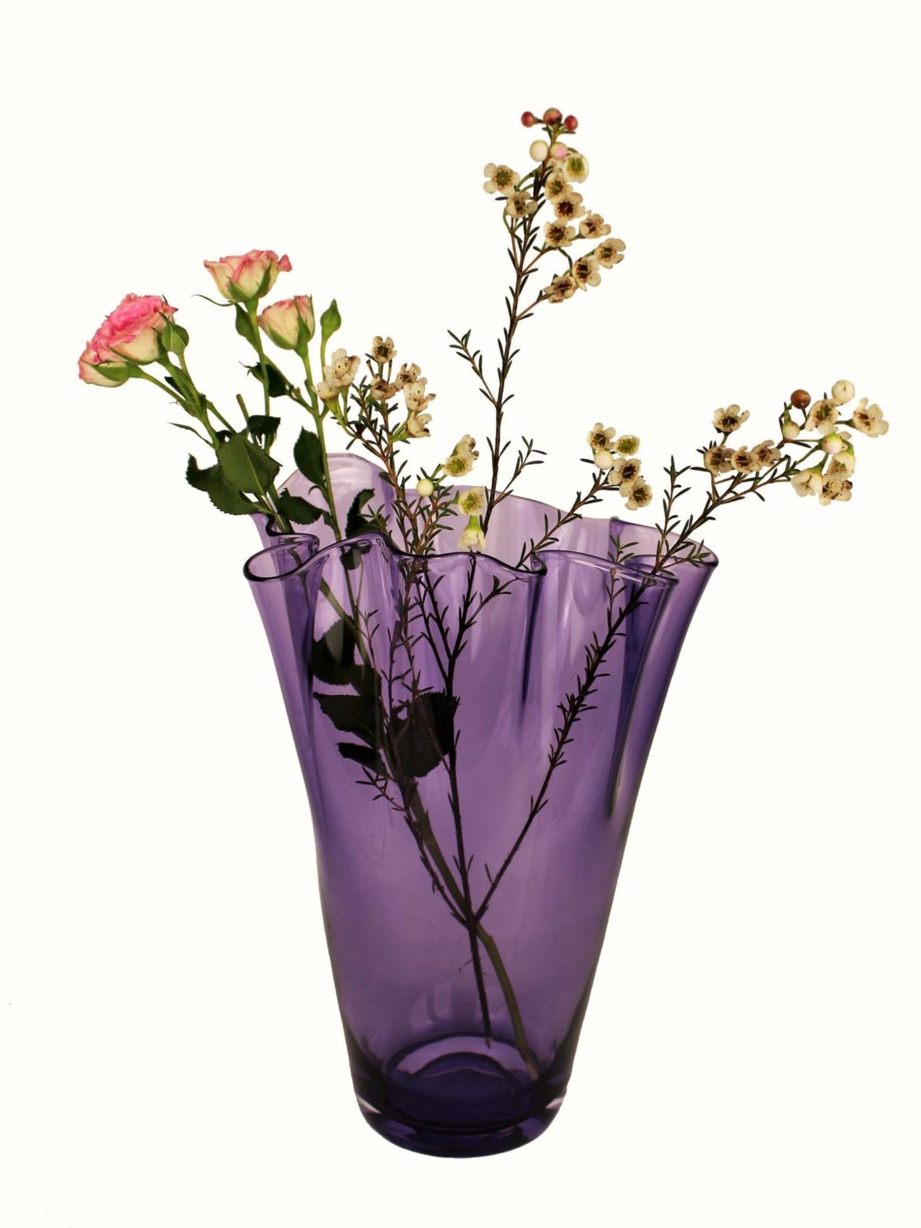 Violette Vase aus Glas mit Blumen dekoriert