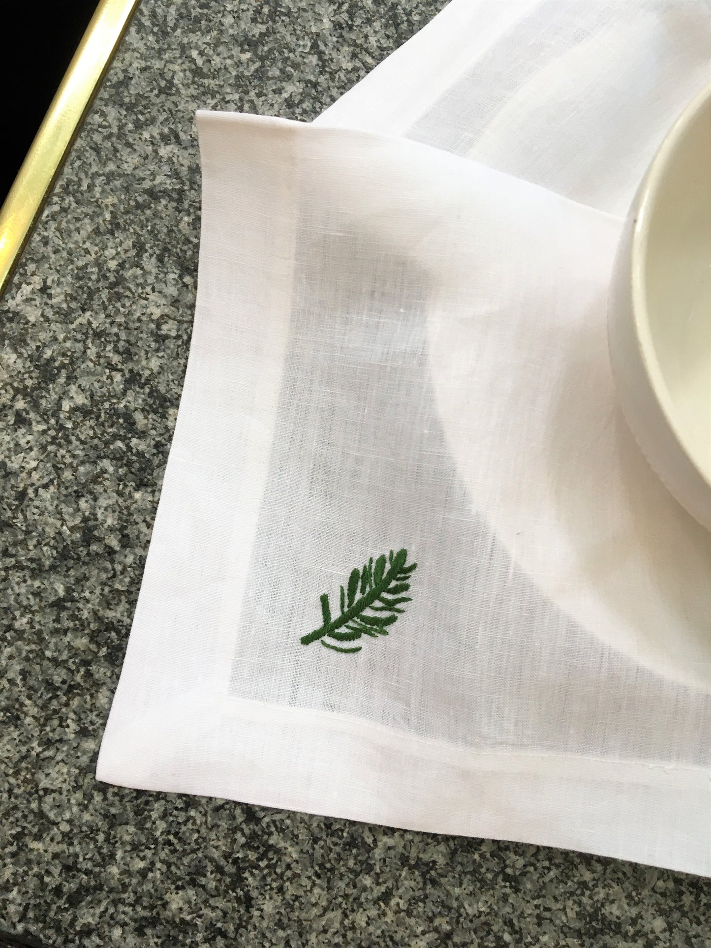 Leinenserviette auf gedecktem Tisch mit Motiv Eibe grüner Zweig