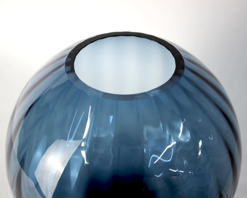 Rundliche Vase in blauem Farbton mit glänzender Oberfläche und Rillen