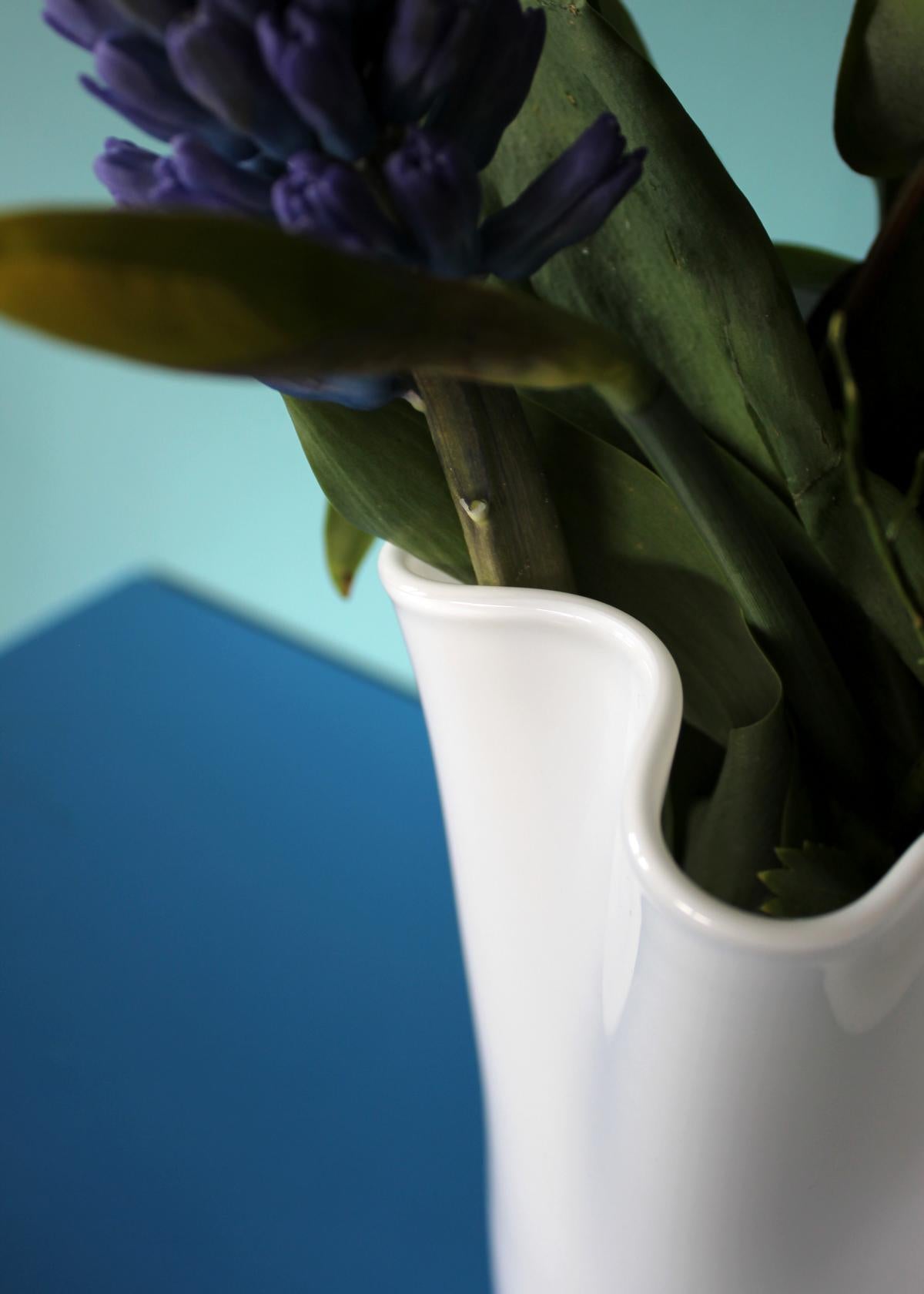 gewellte Glasvase in weiß mit grünem Blumen