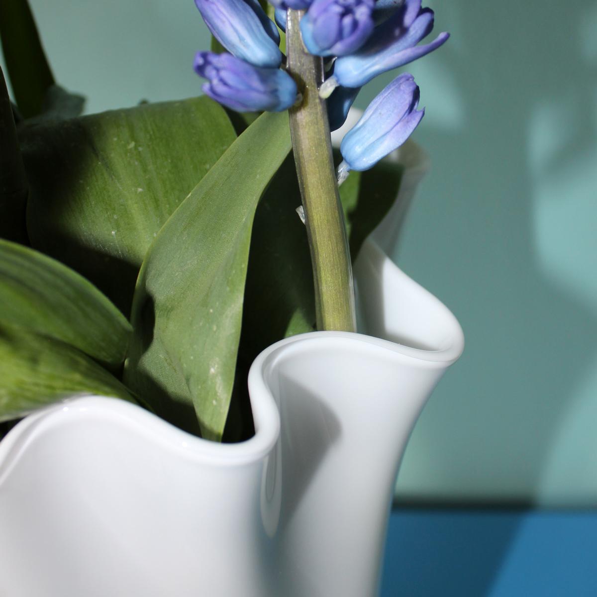 Vase aus Glas weiß mit Blumen drin