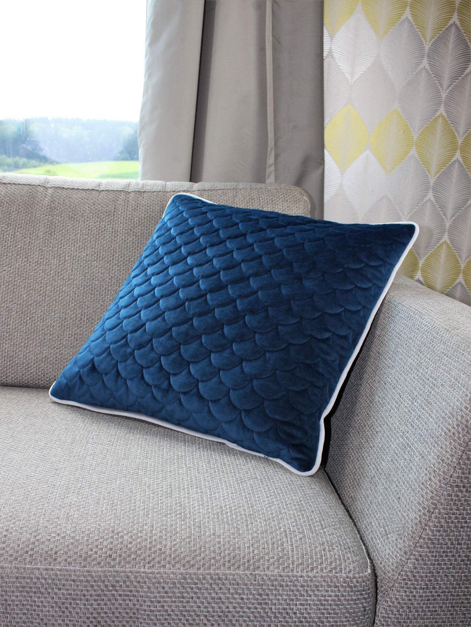 quadratisches Kissen auf Sofa in blauem Samt mit weißem Keder