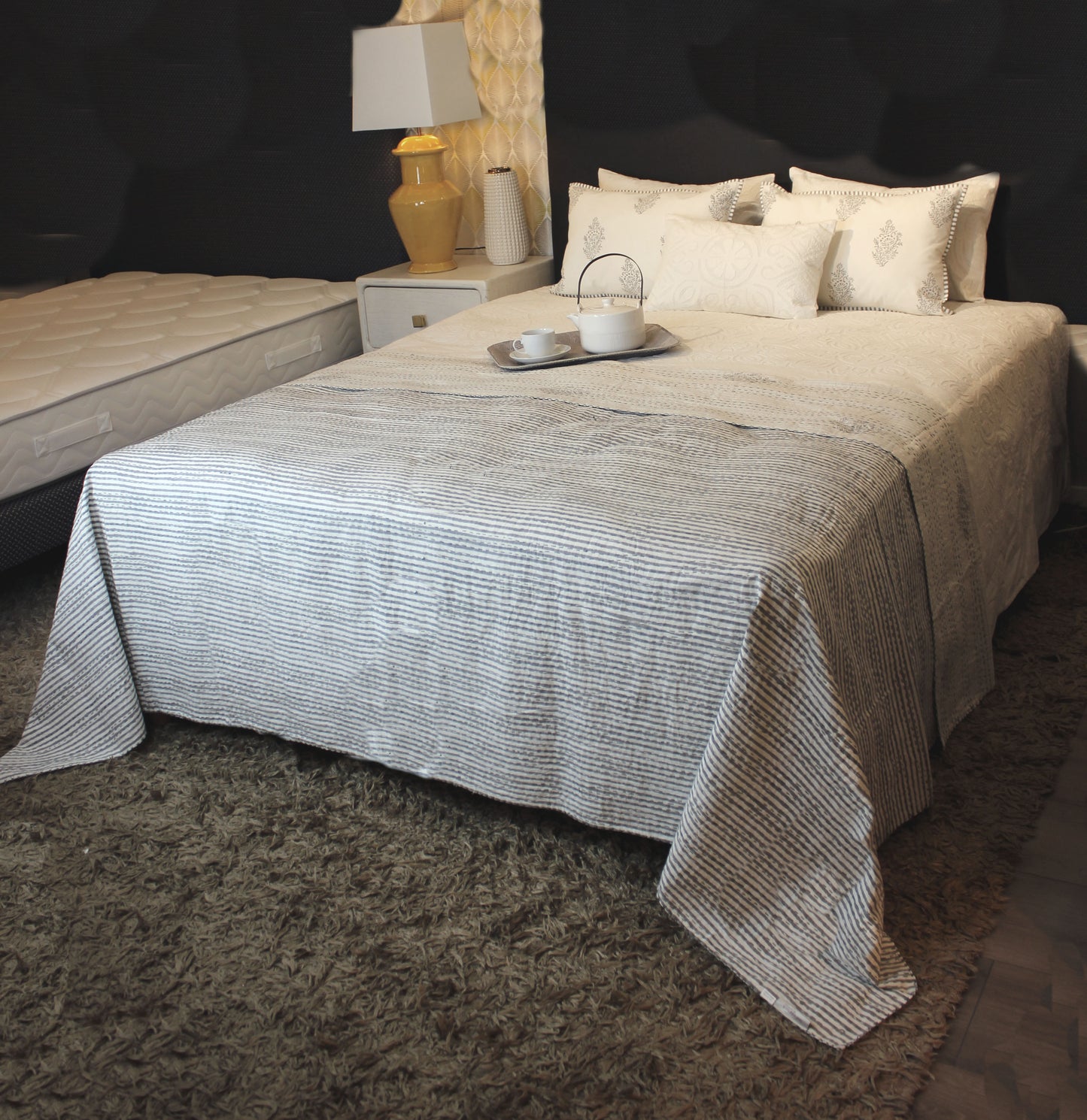 grau weiße Tagesdecke auf Bett mit Kissen dekoriert