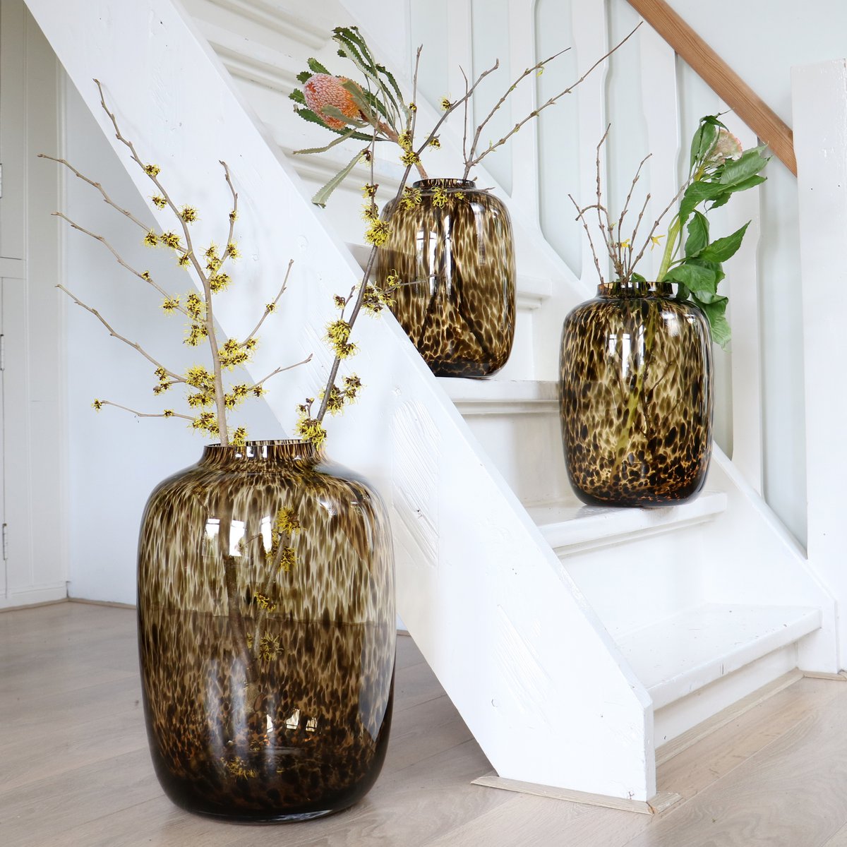 Mundgeblasene Glasvasen Halbdurchscheinend in Braungold gefleckt Mit Zweigen dekoriert auf Treppe