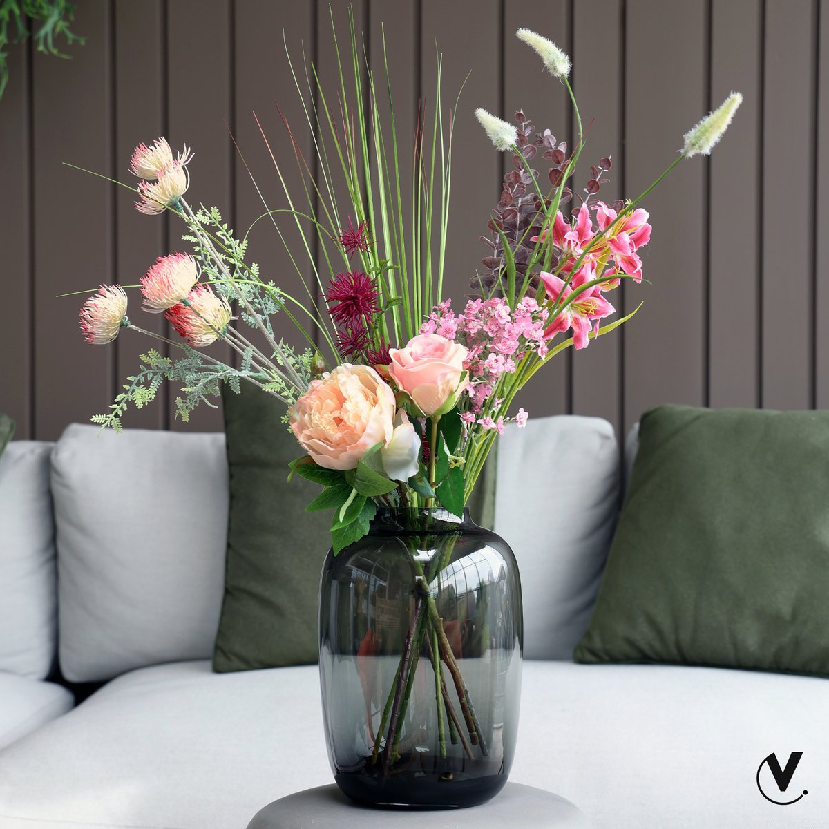 Vase in durchscheinendem Grau dekoriert mit üppigem Blumenstrauß Im Wohnzimmer
