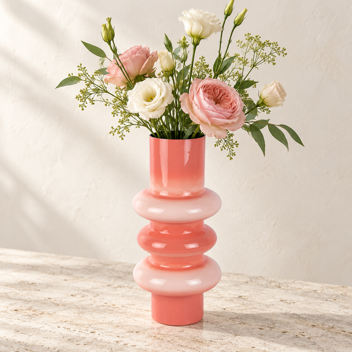 Nahaufnahme der roségoldenen Metallvase Grato mit rosa und cremefarbenen Blumen vor hellem Hintergrund