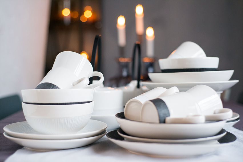 Tassen, Teller und Schüsseln auf dem Tisch aus Keramik in weiß